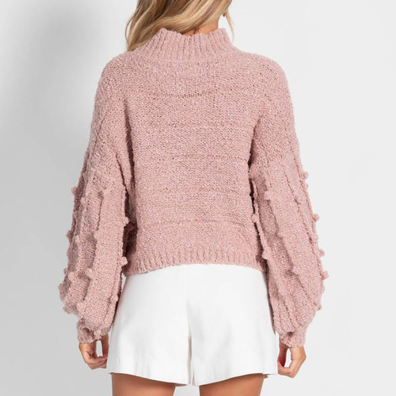 A stylish women's loose sweater with pom-pom sleeves, offering a soft and delightful feel on the skin