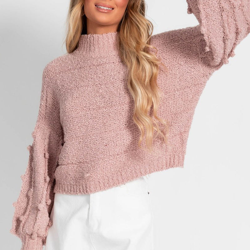 A stylish women's loose sweater with pom-pom sleeves, offering a soft and delightful feel on the skin