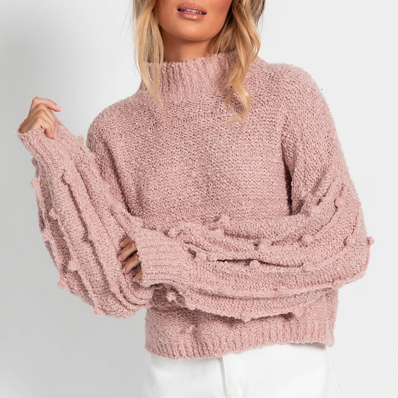 A stylish women's loose sweater with pom-pom sleeves, offering a soft and delightful feel on the skin